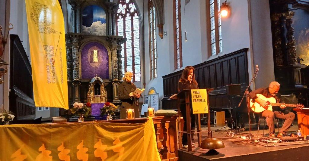 Altarraum der Citykirche. Mehrere Personen tragen Texte aus Büchern vor und es wird Gitarre gespielt.