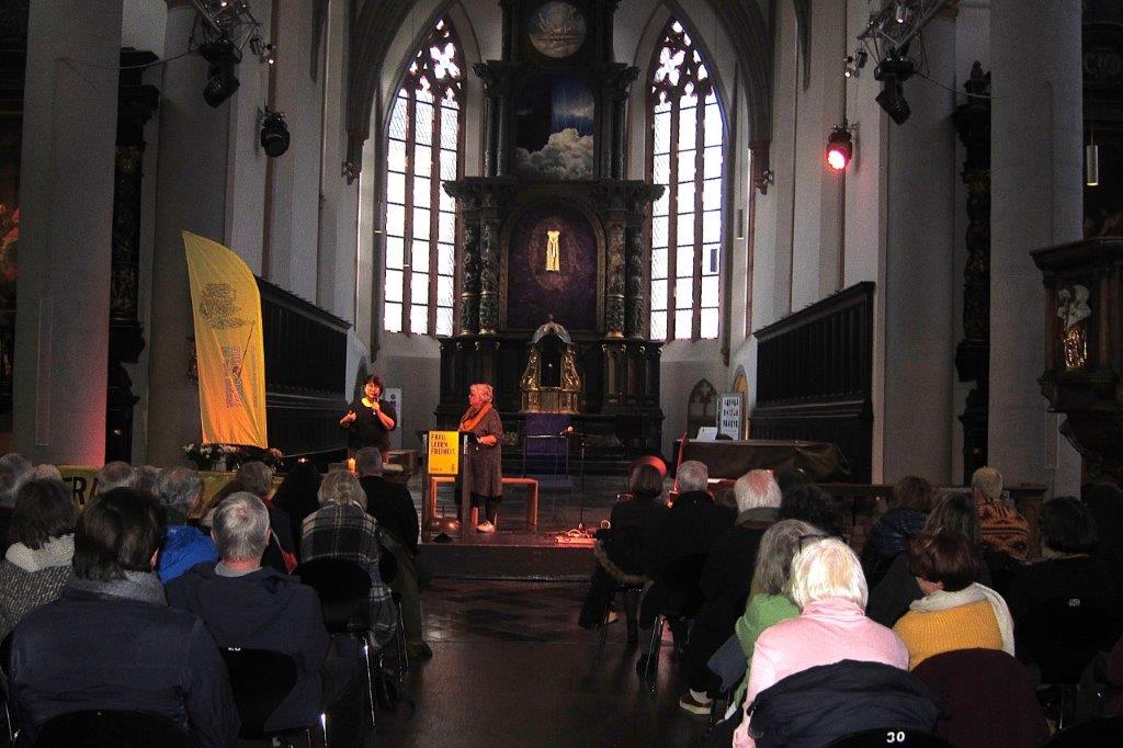 Blick aus über die vollbesetzten Stuhlreihen in den Altarraum der Citykirche. Dort sprechen zwei Personen vor dem Publikum.