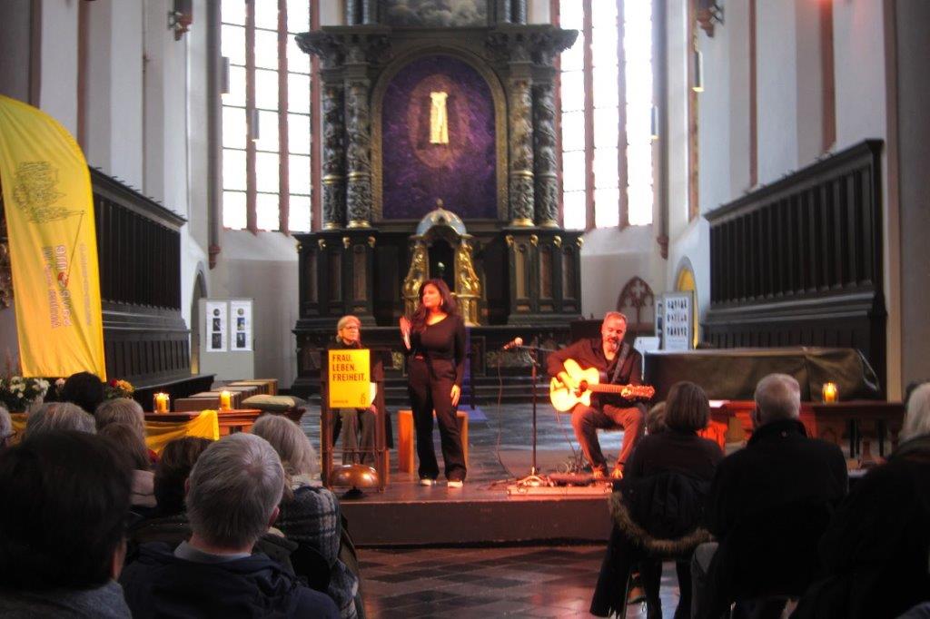 Ein weiterer Blick über das Publikum auf den Altarraum der Citykirche. Es wird gesungen und Gitarre gespielt.