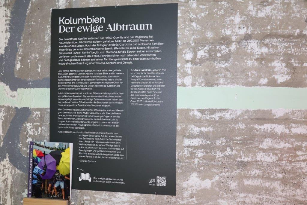 Tafel mit einem Text zu einer Ausstellung an einer Wand mit dem Titel "Kolumbien - Der ewige Albtraum"