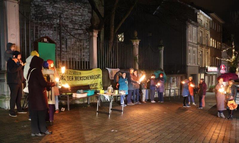 Menschen mit Fackeln bei der Mahnwache am Vorabend des Tags der Menschenrechte vor der Eupener Nikolauskirche.