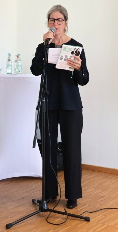 Eine Frau an einem Mikrofon stellt ein Buch vor.
