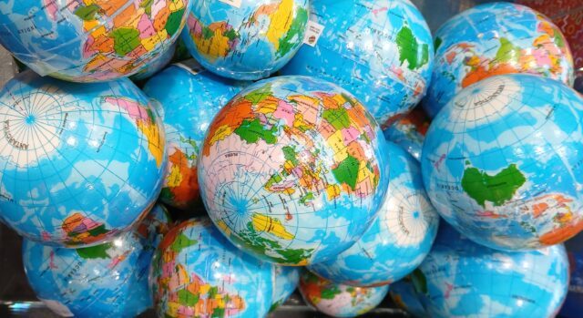 Viele kleine als Globus bedruckte Kugeln liegen auf einem Haufen.