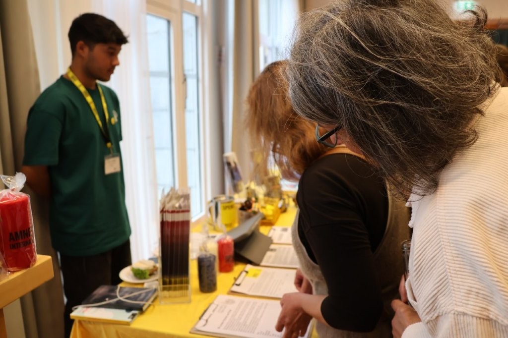 Menschen informieren sich an einem Amnesty-Infostand.