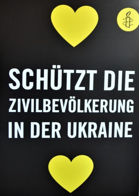 Amnesty-Plakat mit zwei Herzen und der Aufschrift "Schützt die Zivilbevölkerung in der Ukraine"