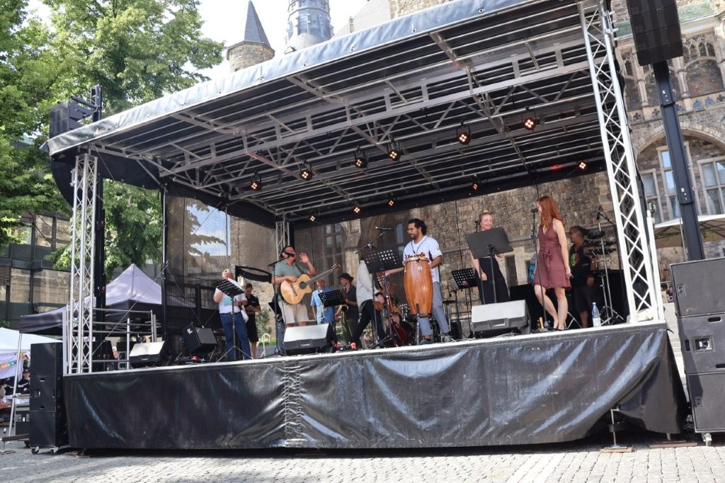 Auf einer Bühne vor dem historischen Aachener Rathaus tritt die Band Sin Fronteras auf.